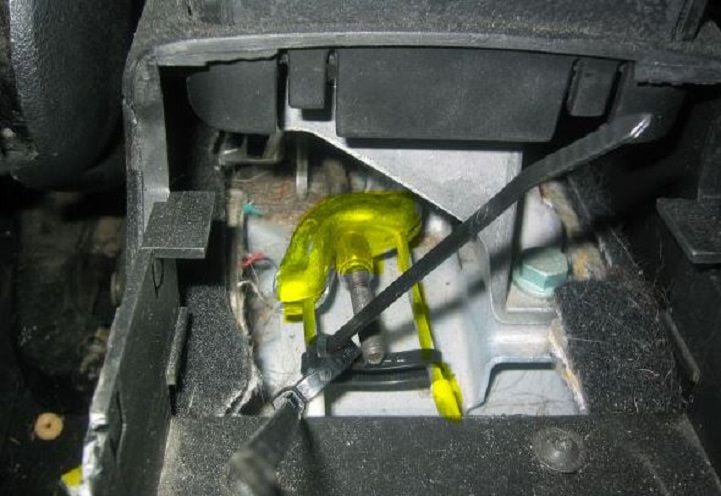 When the console is removed, you'll have access to the emergency brake line ends and adjusting nut