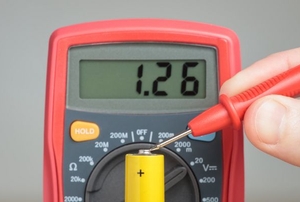 A multimeter reading a battery.