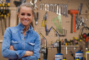 HGTV Star Nicole Curtis standing in a workshop with Bernzomatic blow torches.