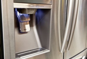 A water and ice dispenser in the door of a stainless steel refrigerator.