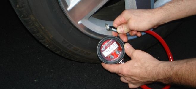 hands checking tire pressure