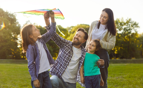 Family flies a kite in the park.