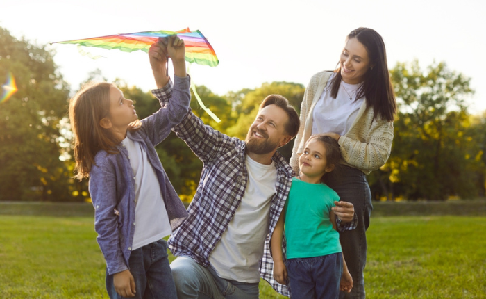 Family flies a kite in the park.