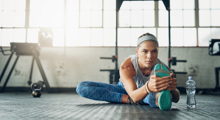 Woman doing hamstring stretch in the gym.