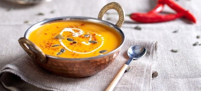 pumpkin soup in a bowl on a napkin with a spoon