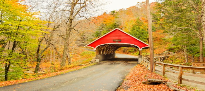 Red, covered bridge with fall foliage