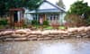 A safe home with sandbags and water surrounding it.