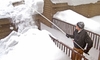 man using roof rake to get snow off his roof