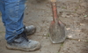 A worker holding a post hole digger.