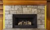 fireplace with stone surround and wood mantle