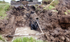 a yard dug up, exposing pipes and water underground