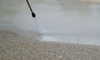 Power washing an exposed aggregate gravel driveway.