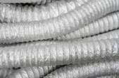 Several tubes of flexible ducting in a pile.