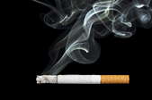 A Cigarette with smoke on a black background.