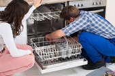 two people looking into a dishwasher