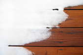 Snow on a wood deck. 