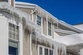 A house with icicles hanging off the roof. 