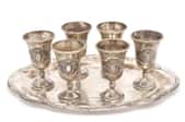 a silver tray holding six silver cups