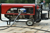 A portable generator with a cord coming out the front.