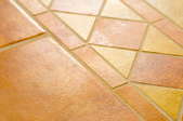 A floor covered in orange-yellow ceramic tiles