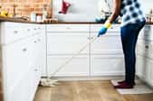 A woman cleans a kitchen.
