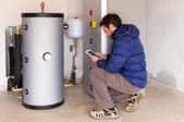 Man looking at electronic tablet while near water heater