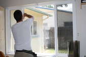 A man installs a window film.