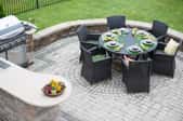 Brick patio with grill and black table with chairs