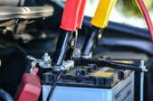 car battery with jumper cables attached