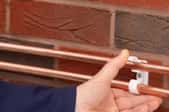 pushing copper pipes into supports