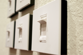 a group of dimmer switches mounted on a cream colored wall