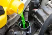 pouring green coolant into a car radiator