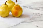 Three pears on a marble surface