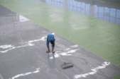 man applying epoxy to a large floor