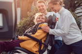 smiling woman in wheelchair with young man and woman