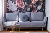 floral wall with gray sofa and wicker table