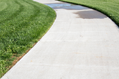a concrete pathway bordered by grass.
