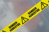 Caution tape warning of asbestos danger.