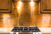 stovetop and counter with copper metal backsplash