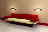 A dark red couch against a cream colored wall.