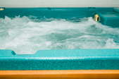 A turquoise hot tub with bubbles. 