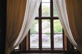 Window with two sets of curtains looking out to garden