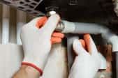 gloved hands insulating pipes