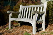 A worn outdoor bench with exposed wood.