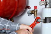 hands using wrench to fix pipes for heating system