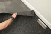 person lifting up rubber flooring