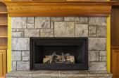 fireplace with stone surround and wood mantle