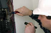 A man inspects a circuit breaker.