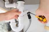 hands installing bathroom sink plumbing