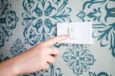 A light switch on wallpaper.